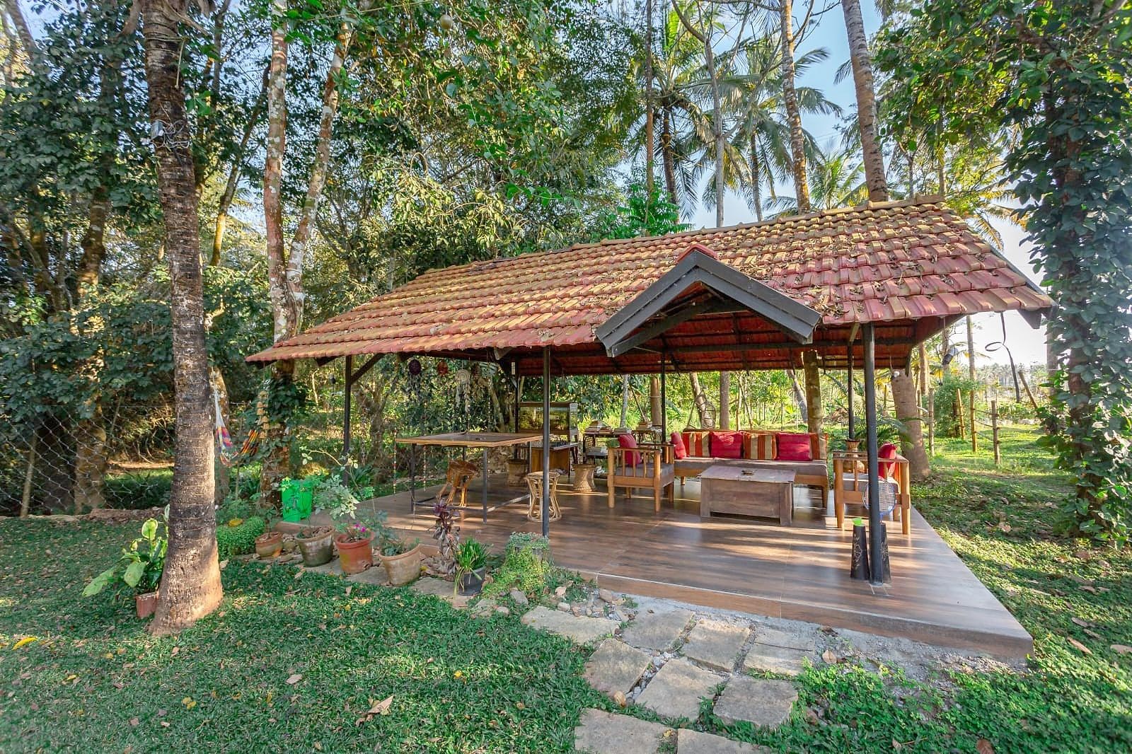 A gazebo in the garden among palm trees