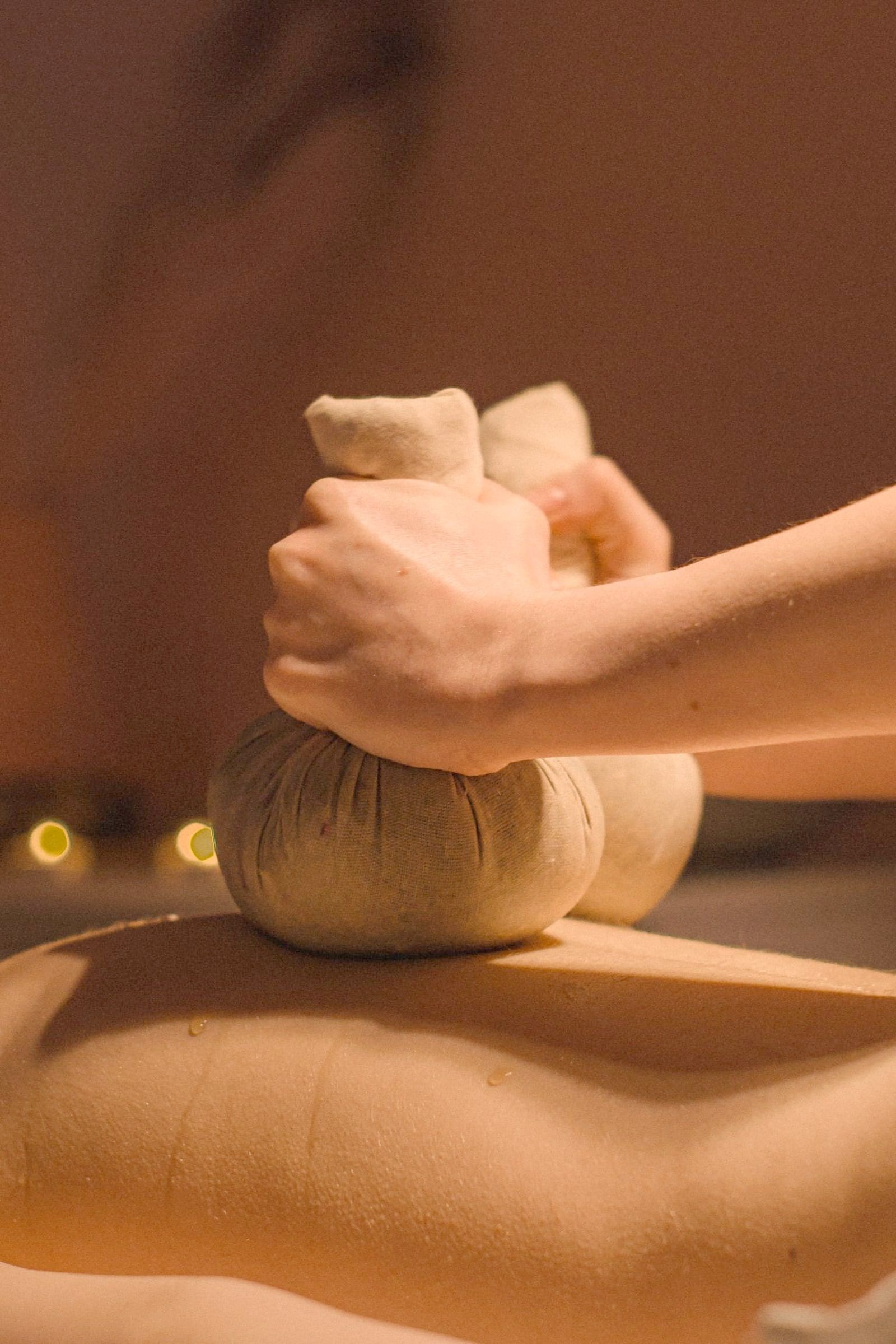 Herbal boluses in a therapist's hands