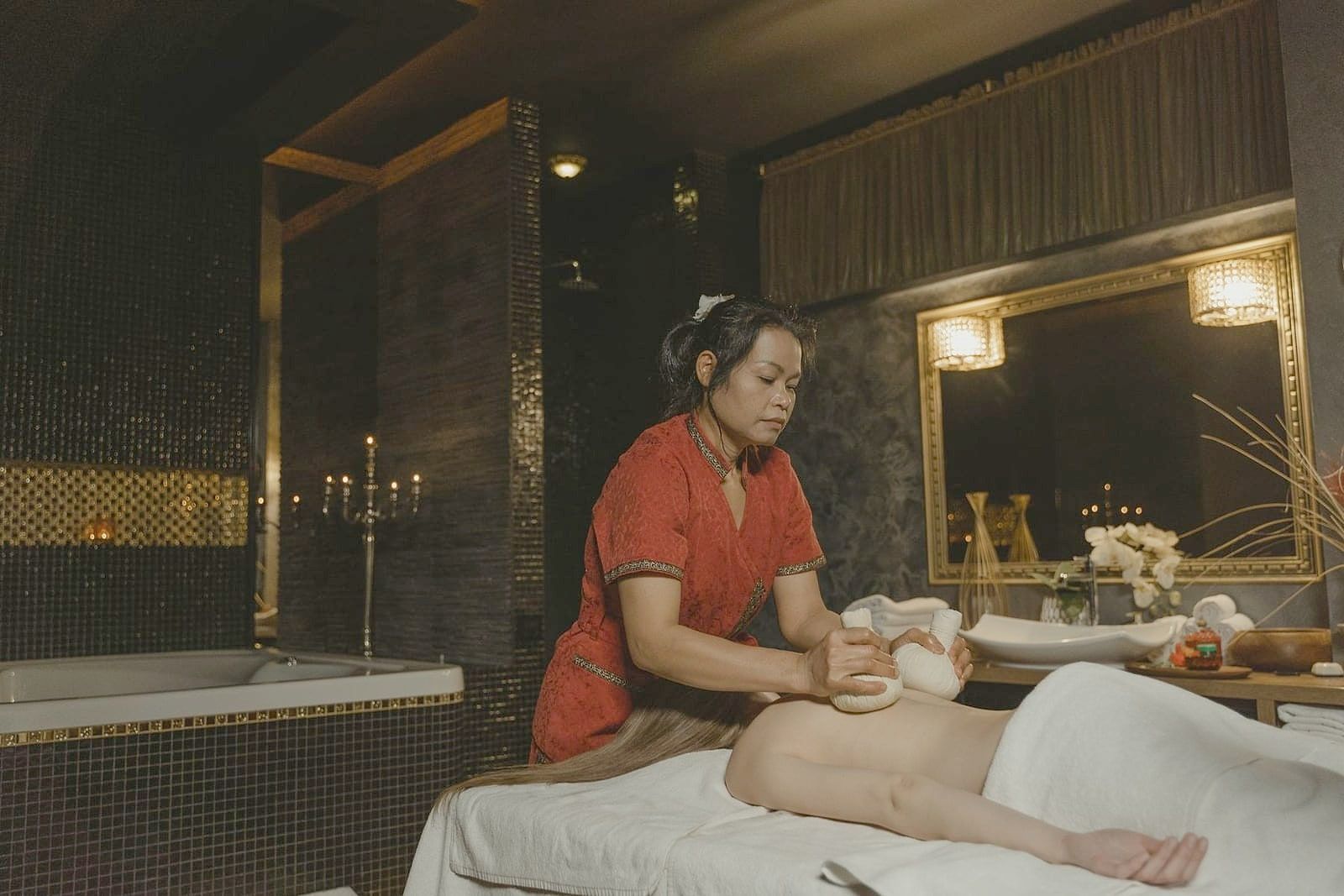 A therapist preparing a treatment with herbal boluses
