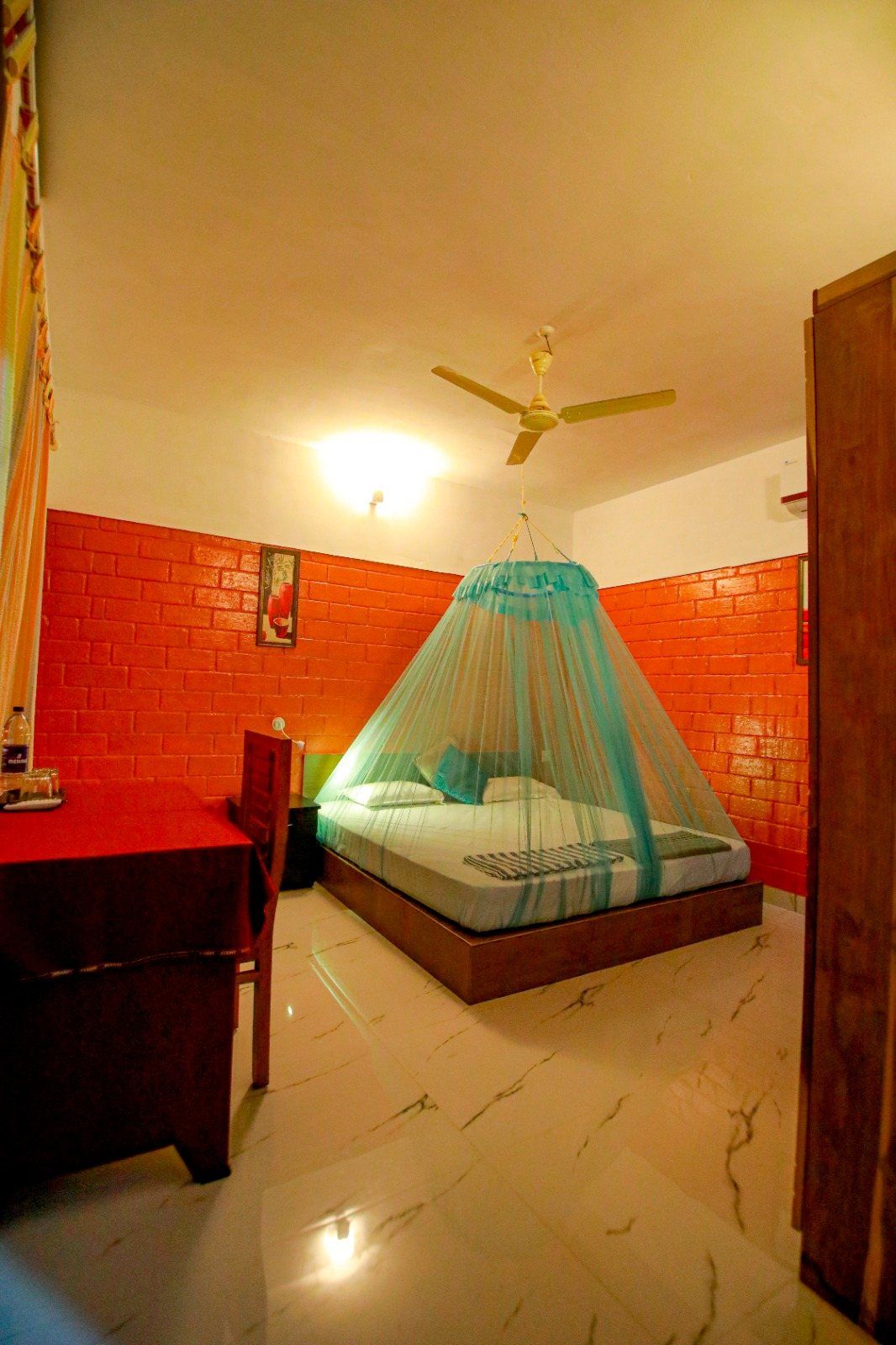 A room in the evening: bed with a mosquito net, warm light
